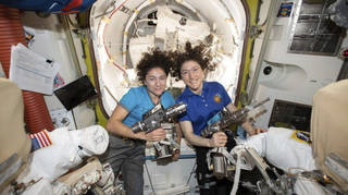 Astronauts Jessica Meir, left, and Christina Koch pose for a photo in the International Space Station