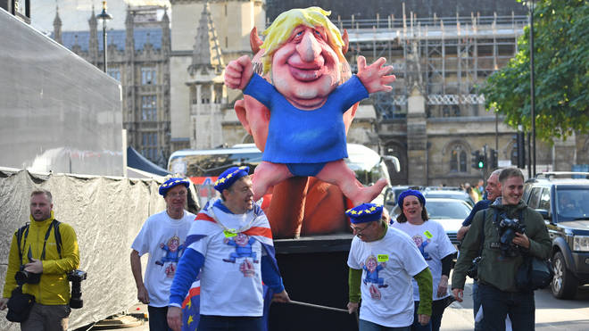 Protesters pull a float depicting Prime Minister Boris Johnson outside the Houses of Parliament in London after he delivered a statement in the House of Commons on his new Brexit deal on what has been dubbed "Super Saturday".