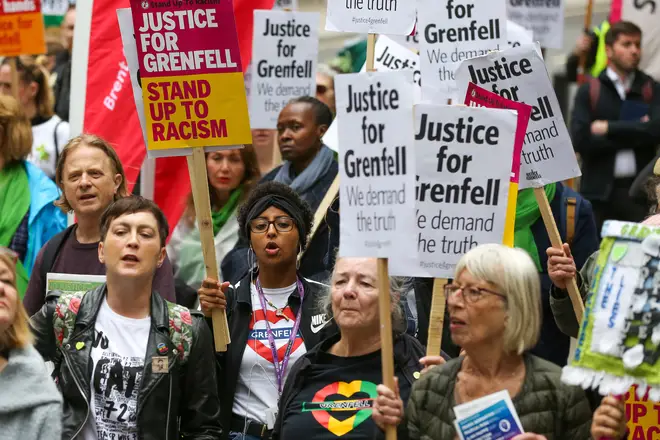 Campaigners hold placards as they take part during the Justice for Grenfell Solidarity rally this June