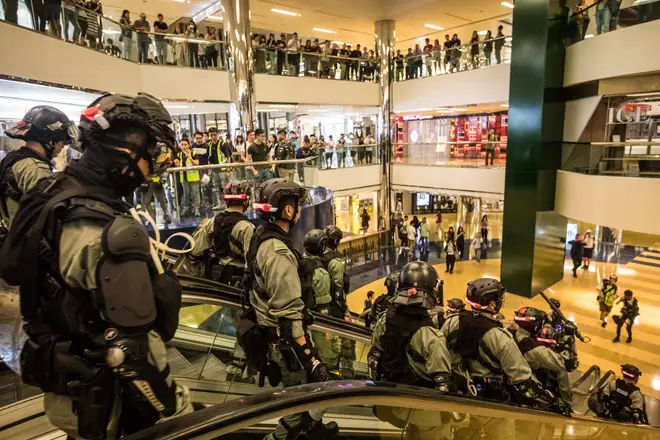 Riot police descend an escalator inside the City Plaza shopping centre in Hong Kong