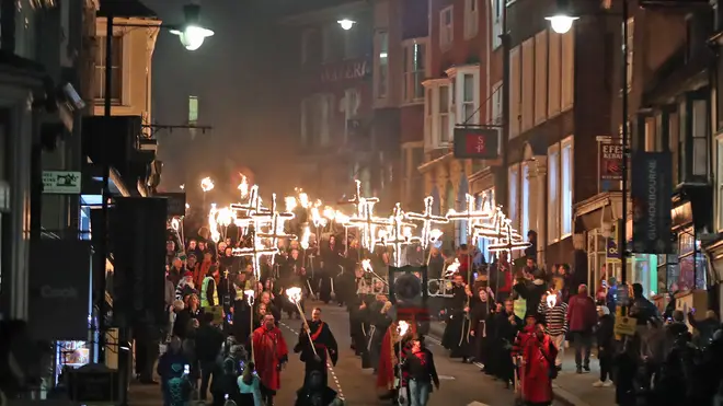 People in Lewes, east Sussex, make their way through the procession