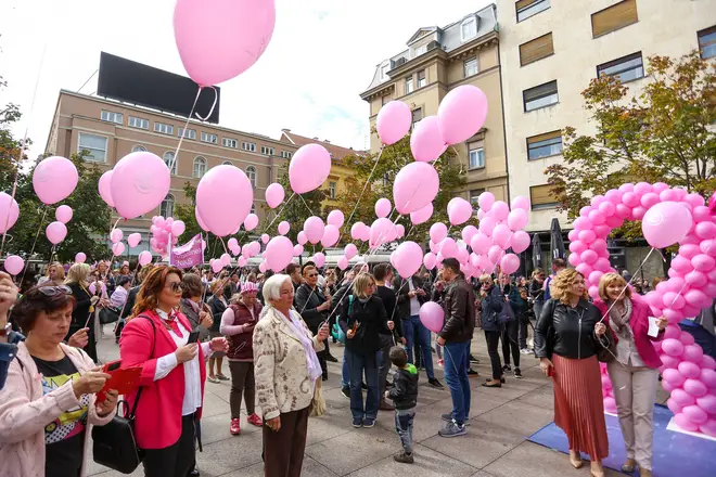People hold pink balloons during breast cancer campaigning in Croatia
