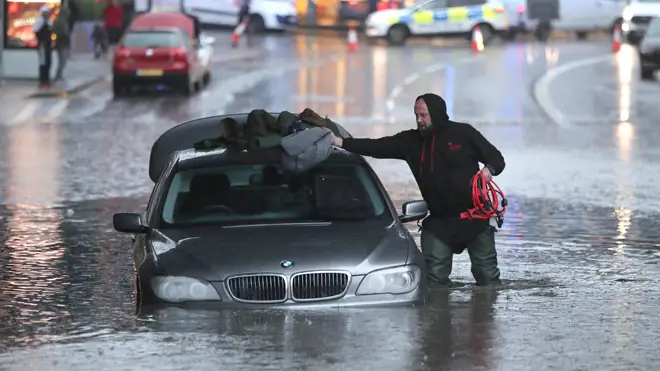 A man retrieves his belongings from his stranded car in Sheffield