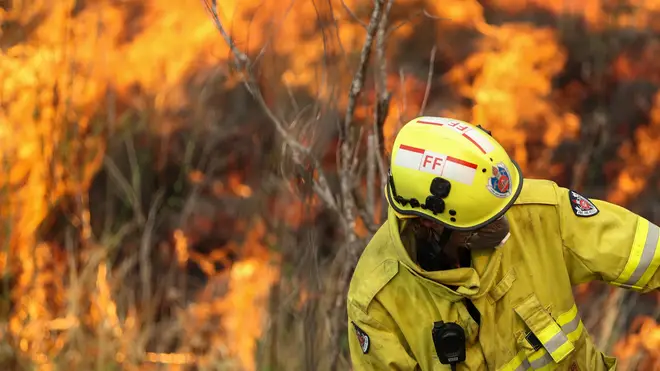 A firefighter battles the flames during bushfires near Taree, New South Wales, Australia