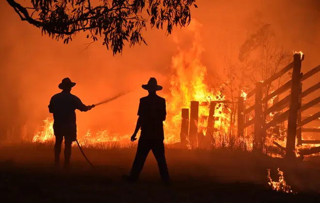 Residents defend a property from a bushfire, 350km north of Sydney. PETER PARKS / Contributor