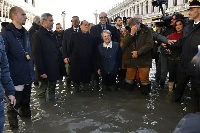 Former Italian Premier Silvio Berlusconi, center left in a flooded St. Mark's Square in Venice