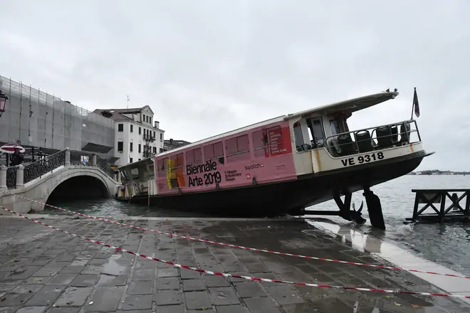 A stranded ferry boat lies on its side in Venice