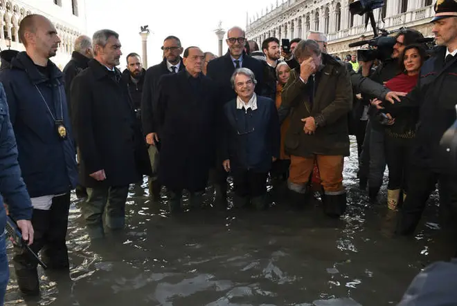 Former Italian Premier Silvio Berlusconi, center left in a flooded St. Mark's Square in Venice.