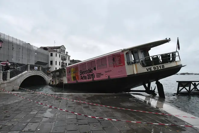 A stranded ferry boat lies on its side in Venice.