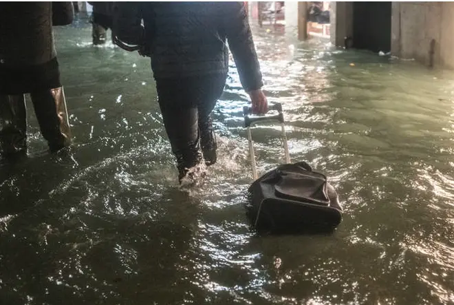 A tourist walks near a store after the exceptional high tide or 'Alta Acqua' that reached 190 cm at late night.