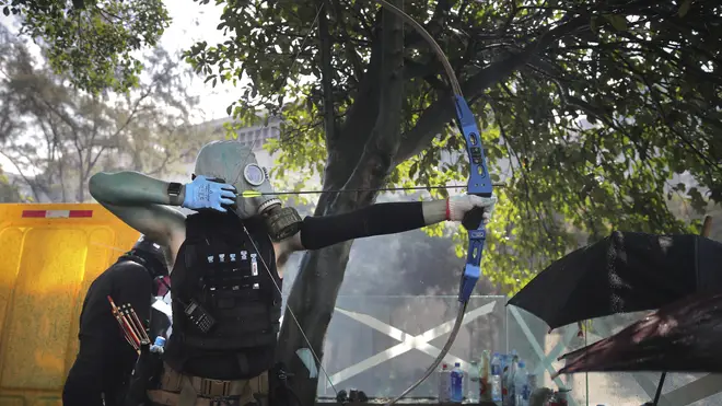 A protester with a bow prepares to fire