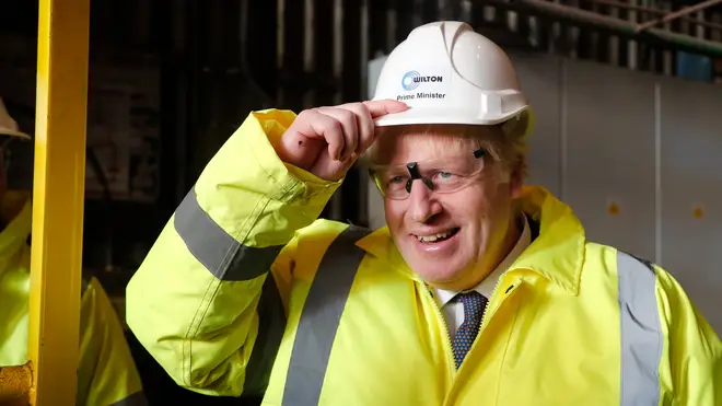 Boris Johnson wears a construction helmet reading "Prime Minister" during a visit to Wilton Engineering Services