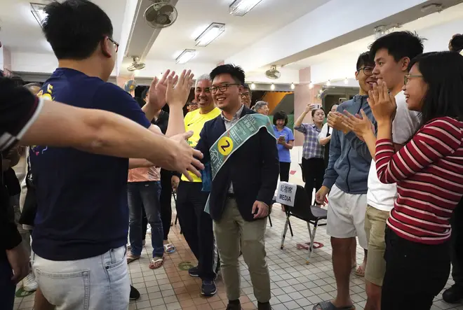 Pro-democracy candidate James Yu, center, celebrates with supporters after winning his seat in district council elections in Hong Kong.