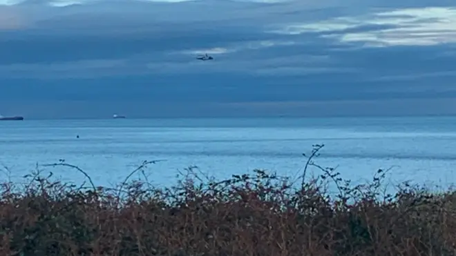 A coastguard helicopter searches for the plane off the coast of Anglesey